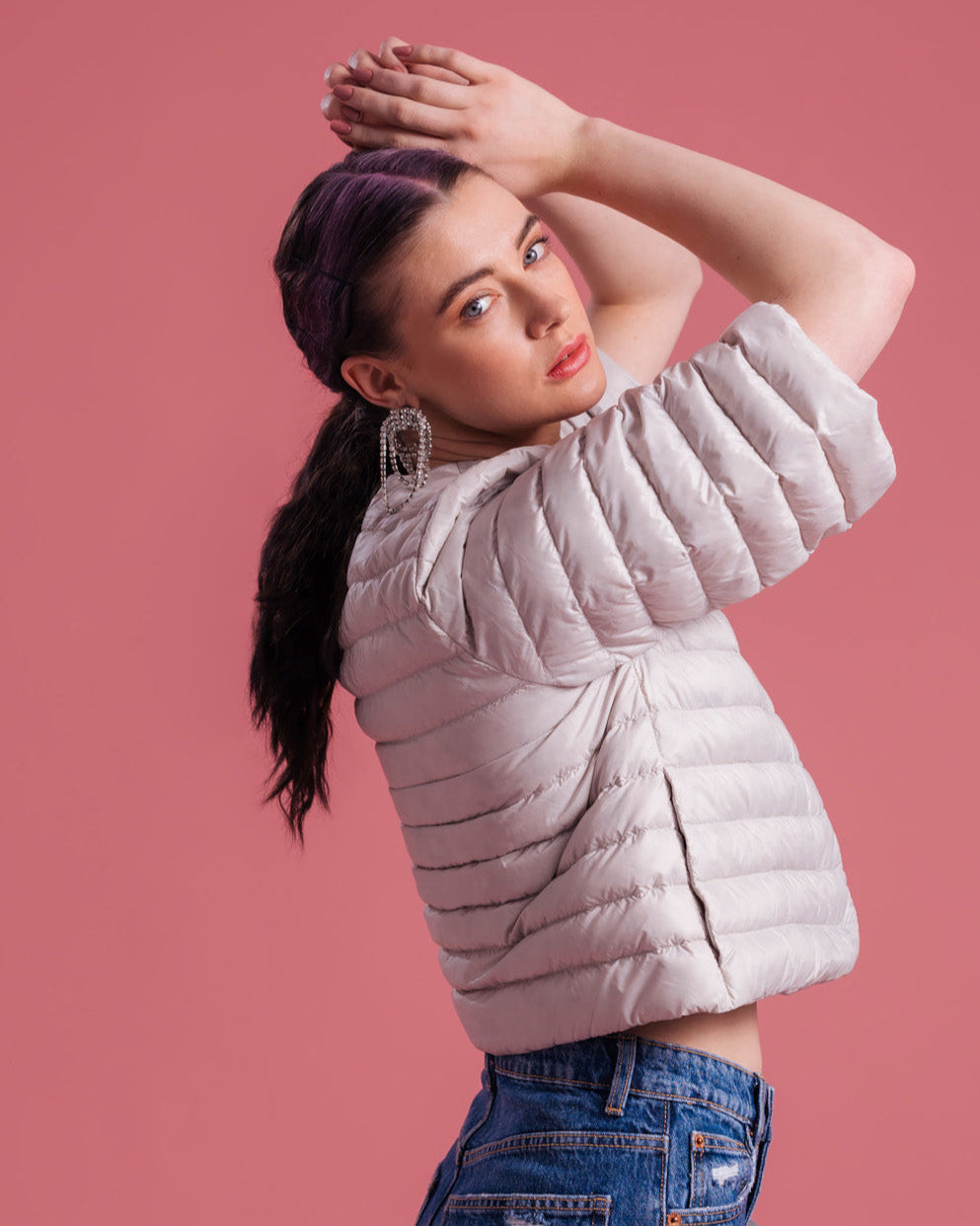 Nainen pukeutuneena vaaleaan, lyhyeen ja kevyesti topattuun Lupiini-kevytuntuvatakkiin (väri: sokeripilvi), jossa on 3/4-pituiset leveät hihat ja vaakasuuntaiset tikkaukset. Takki on yhdistetty sinisiin farkkuihin.