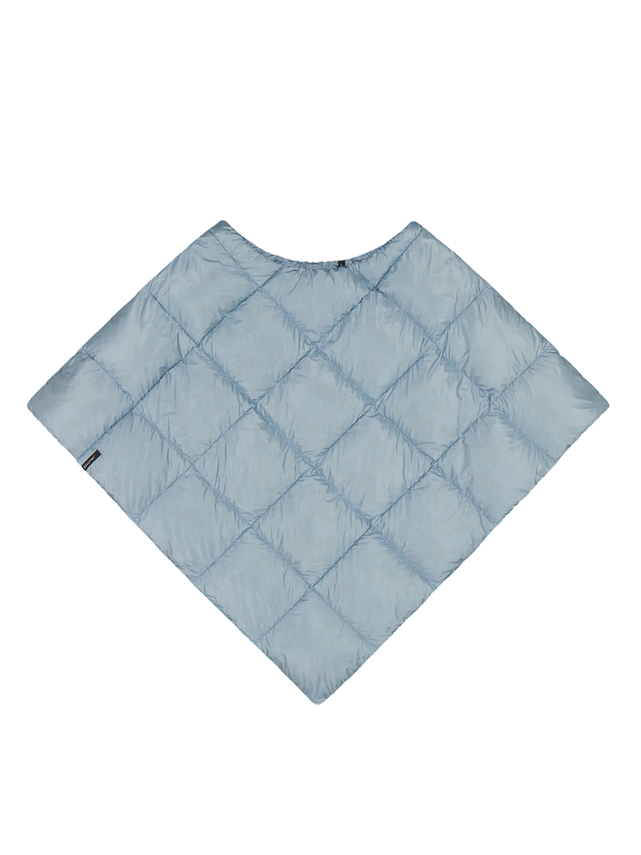 Jäänsininen, timanttikuvioisesti tikattu Unelma-untuvaponcho. Ponchossa on pyöreä pääntie ja se levenee hartioilta alaspäin muodostaen kulmikkaan siluetin. Vasemmassa reunassa pieni musta tuotemerkki.