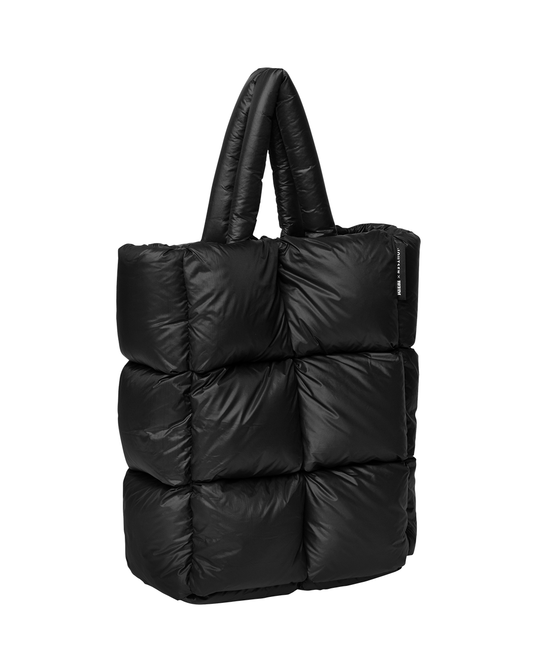 Musta, muhkeasti topattu Muutos-untuvalaukku, jossa on pehmustetut kantokahvat ja neliömäisistä osista muodostuva ulkopinta.